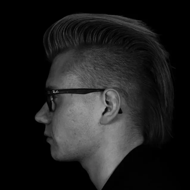 Homem de perfil com topete penteado para trás